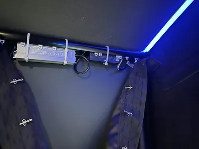The WLED controller and power supply zip-tied out of sight behind the impact screen, with a blue glow from the strip.