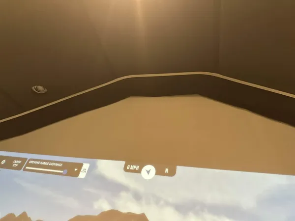 A flexible silicone LED diffuser tucked into the gap between ceiling panels above the screen, glowing softly.